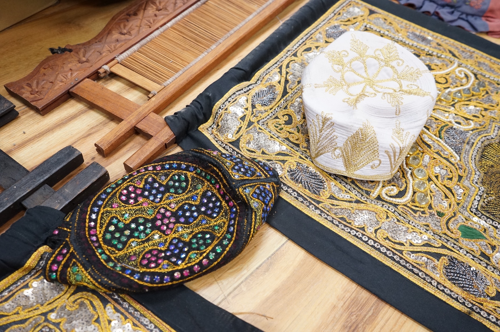A quantity of mostly 20th century Middle Eastern and Indian woven and printed textiles and a peacock feather fan (2 boxes).